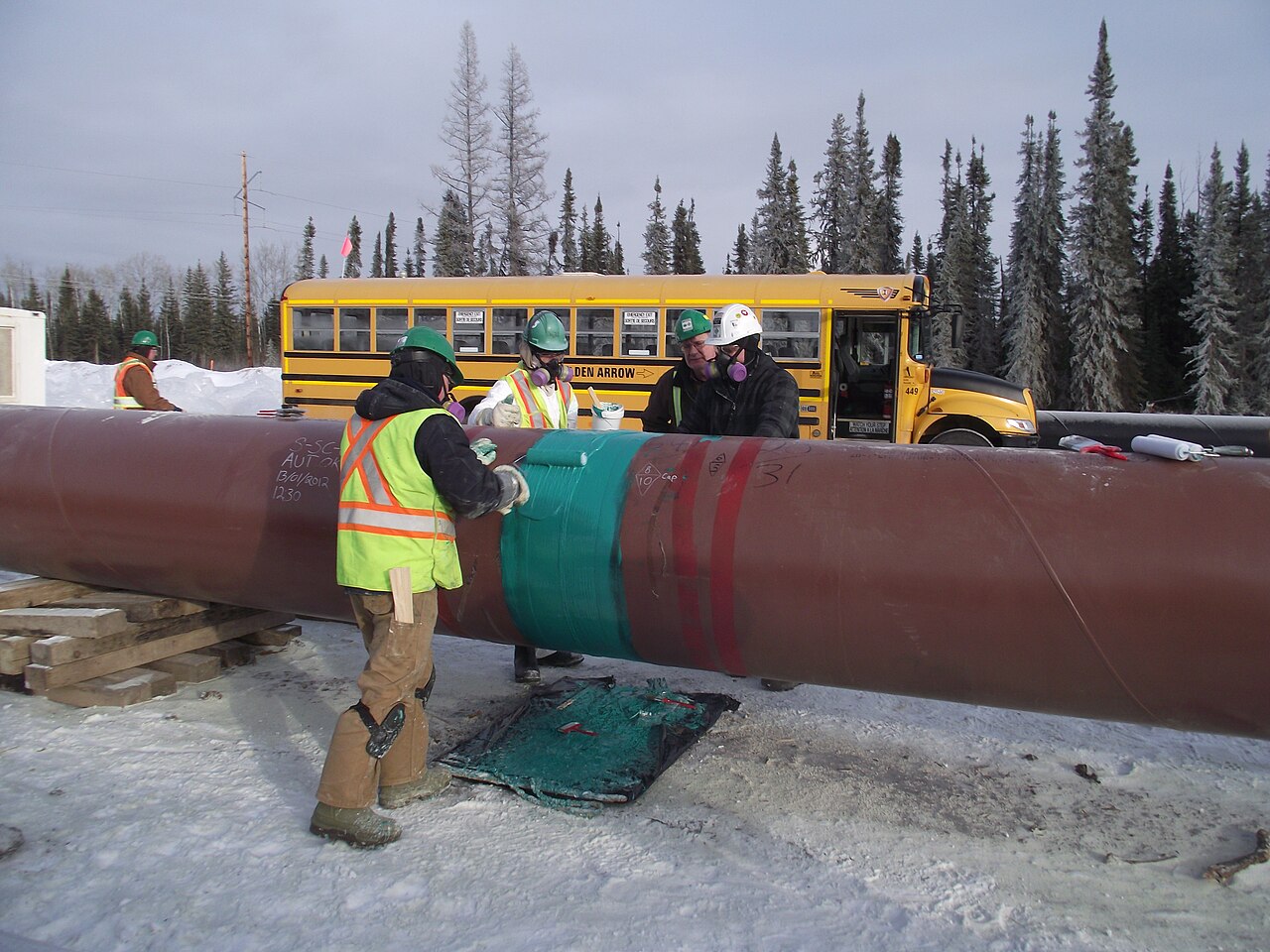 Crew applying protective coating to a pipeline